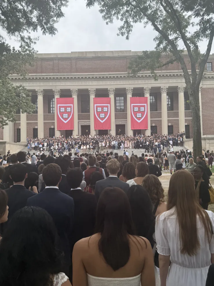 3 large banners hang from the Widener library columns displaying the Harvard Emblem