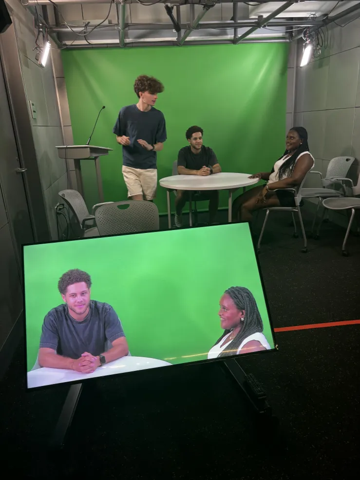 An image of me, SRA Eli, and SRA Tye in a green screen room in Cabot Science Library