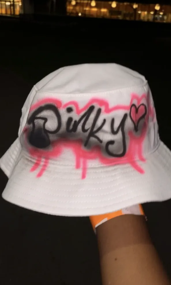 bucket hat with the word 'pinky' written across it