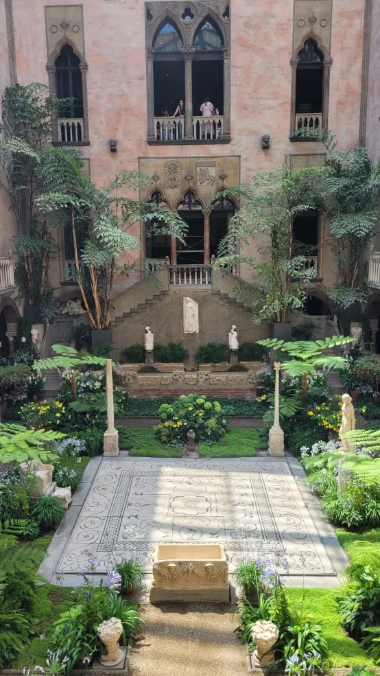 a stone courtyard with vibrant greenery and sculptures