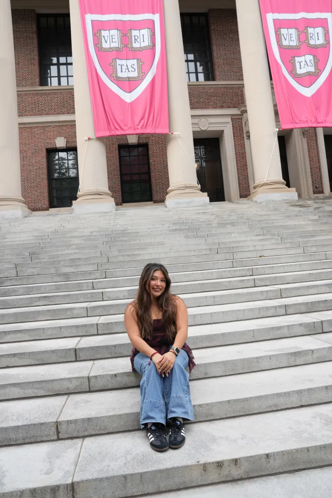Author in front of Widener Library with the three Harvard Veritas flags hanging down.