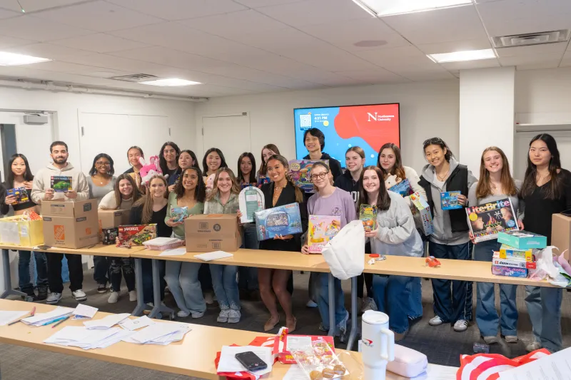 Olivia Zhang '27 surrounded by volunteers at a toy drive.