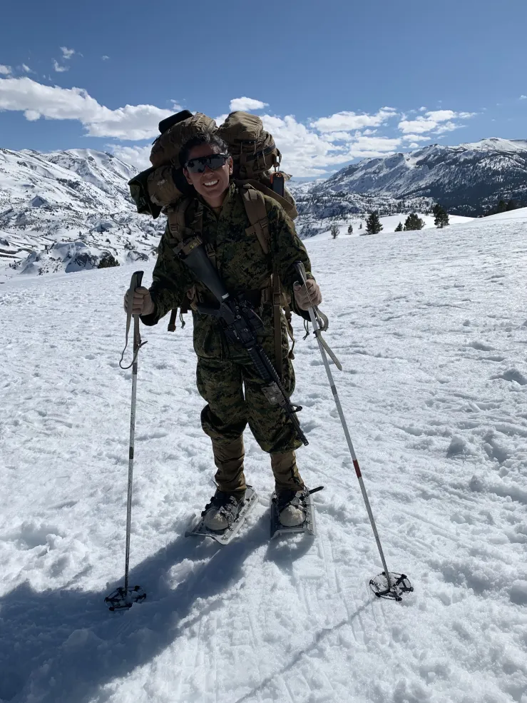 Vanessa Valverde atop a snow-covered hill in California in her military uniform, participating in cold weather training.