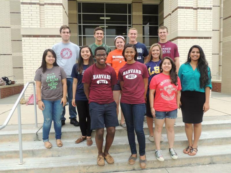 Author and high school friends wearing different college shirts on steps of building