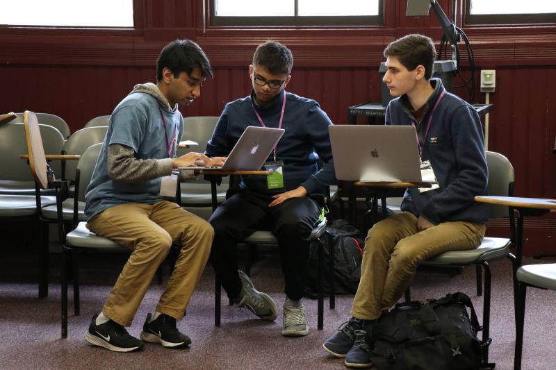 three students at desks working together