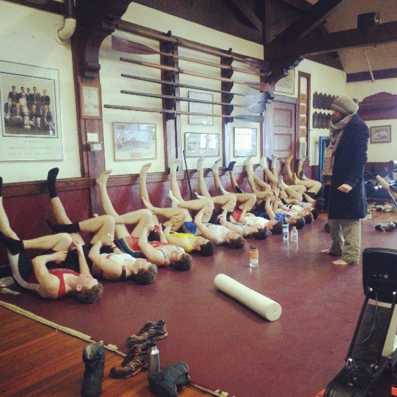 Rowing team stretching in the boathouse