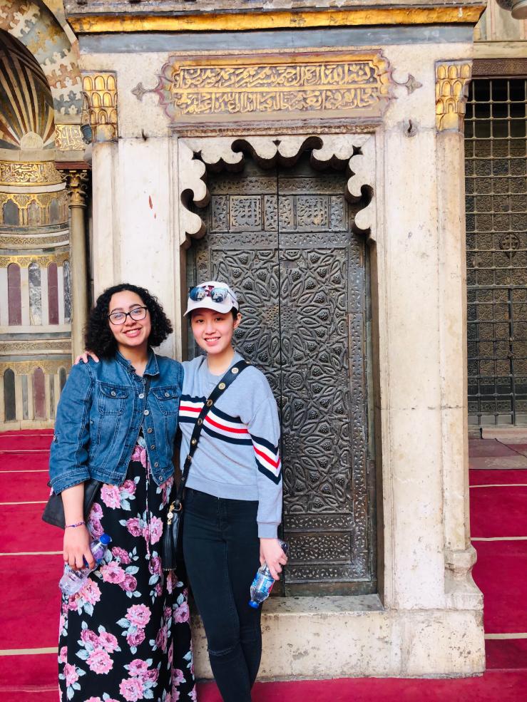 Two students in front of a mosque