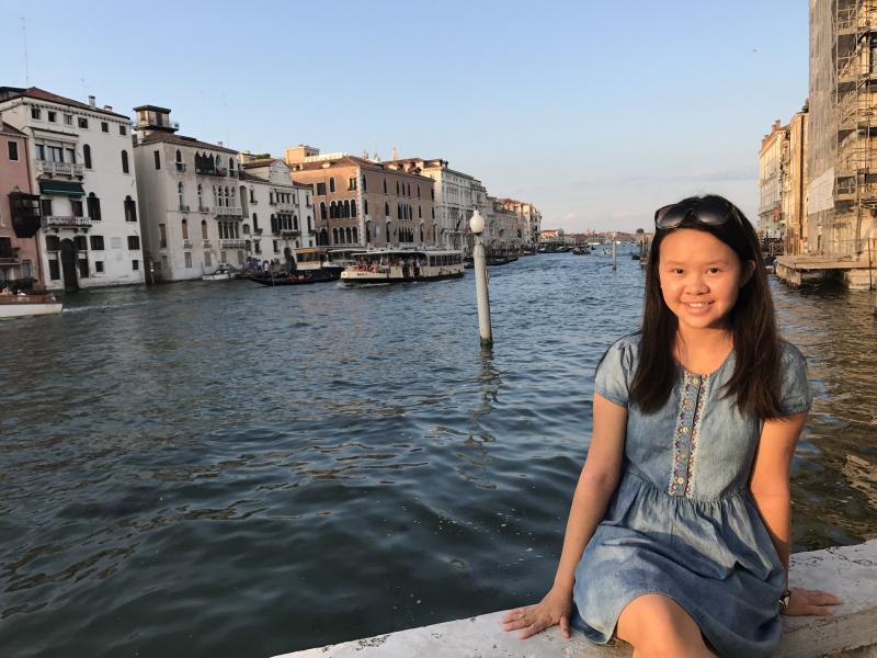 Author sitting on bridge over canal