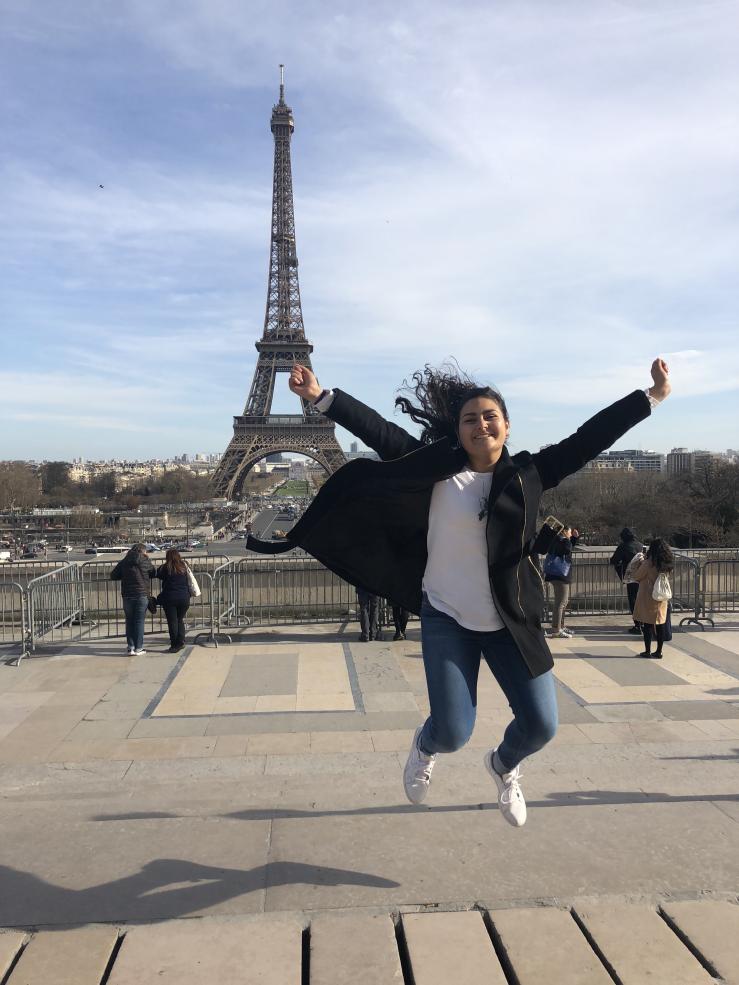 student jumping in front of the Eiffel Tower