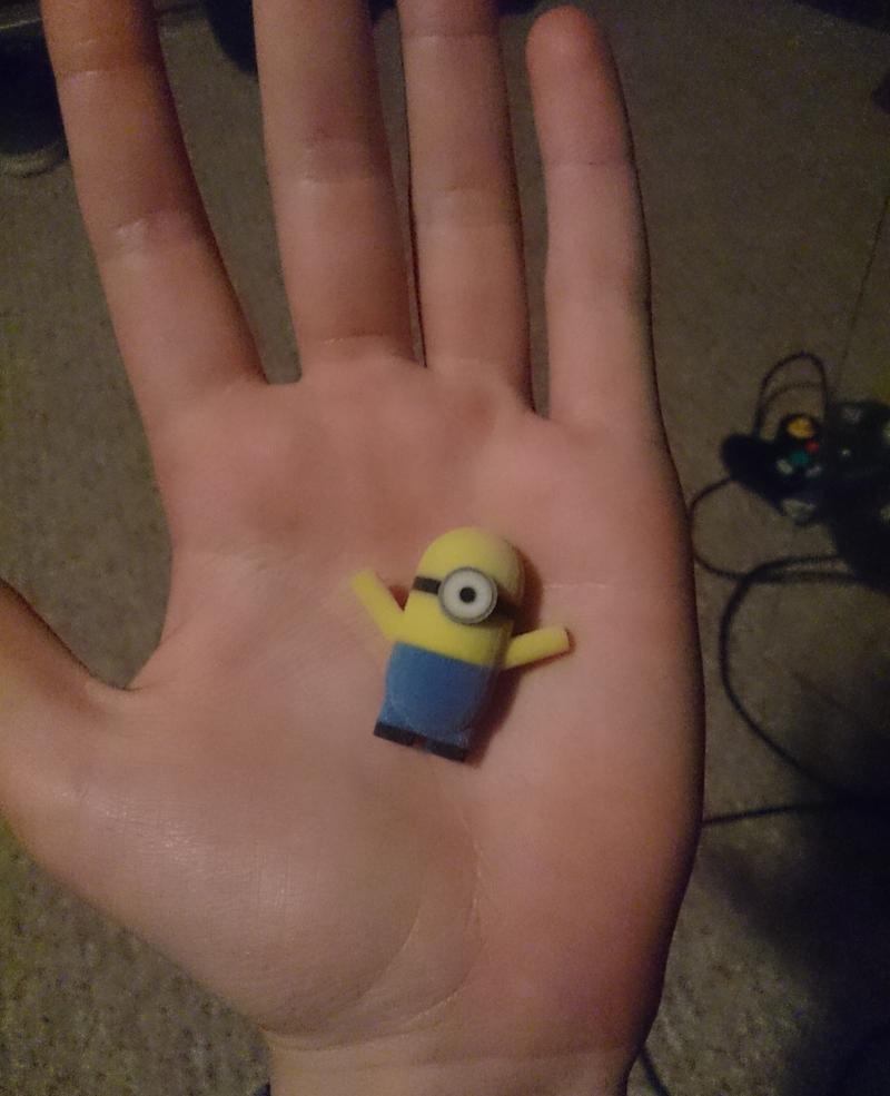 Photograph of author holding a toy "minion" from the film "Despicable Me"