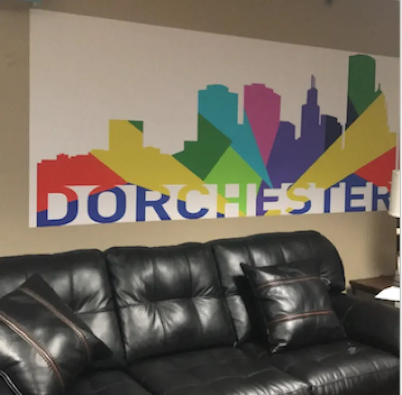 Couch under a poster of colorful buildings and the word Dorchester 