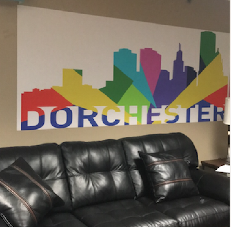 Couch under a poster of colorful buildings and the word Dorchester 