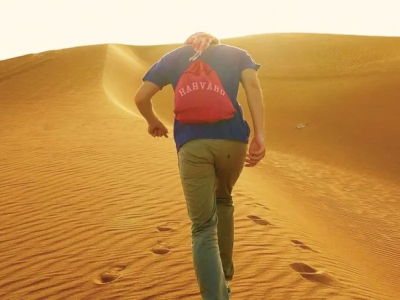 Student with Harvard backpack in desert