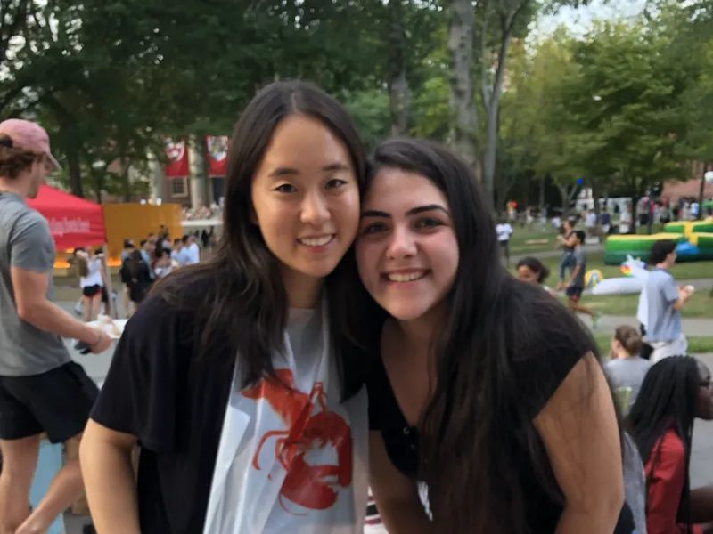 two students eating lobster in Harvard Yard