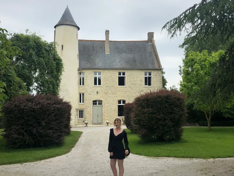 Malia at Chateau Monfreville, a castle in northern France, with greenery and sky in background