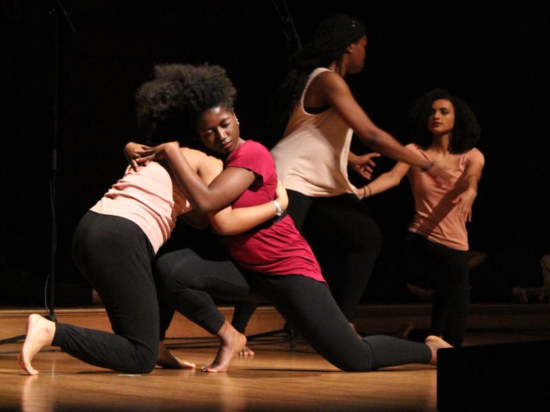 This image shows 4 dancers embracing each other at last year's Kuumba Winter Concert.