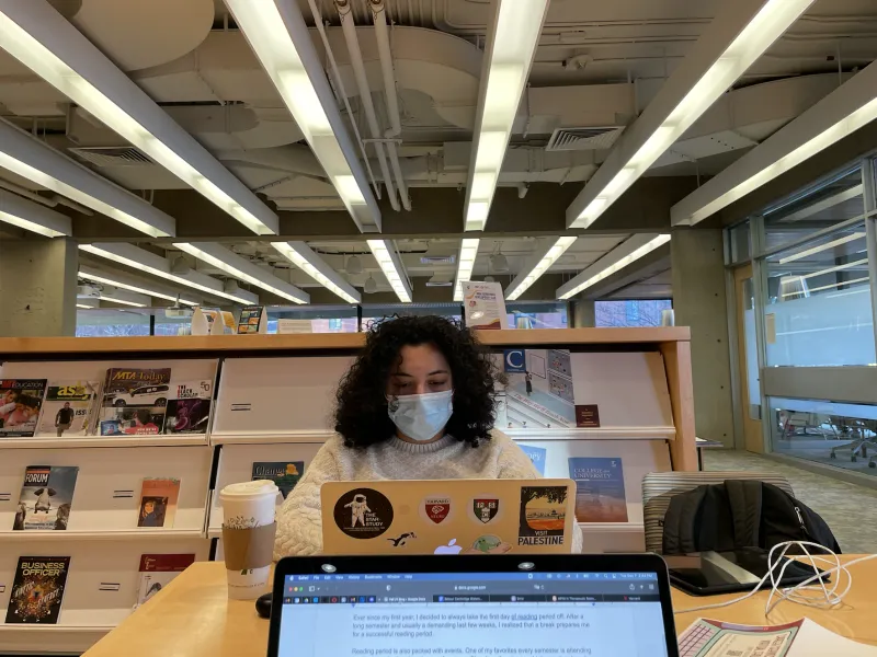 Student typing on computer in a common study space