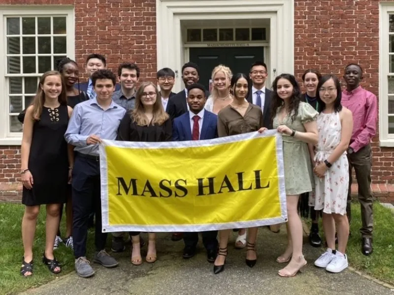 A picture of Mass Hall residents holding a yellow "Mass Hall" banner.
