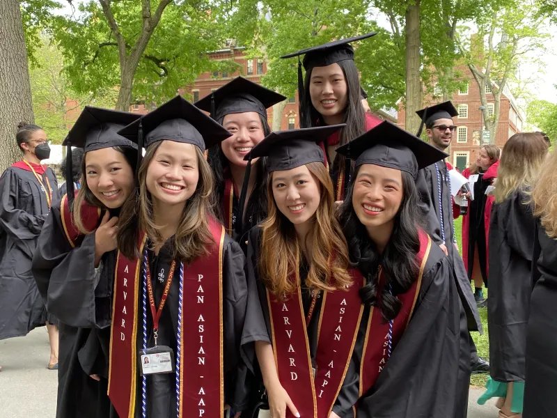 female students in cap and gown on commencement day wearing Pan Asian AAPI around their robe