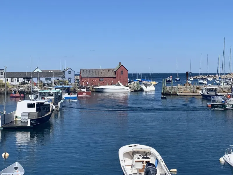 A red farmhouse surrounded by water and boats.