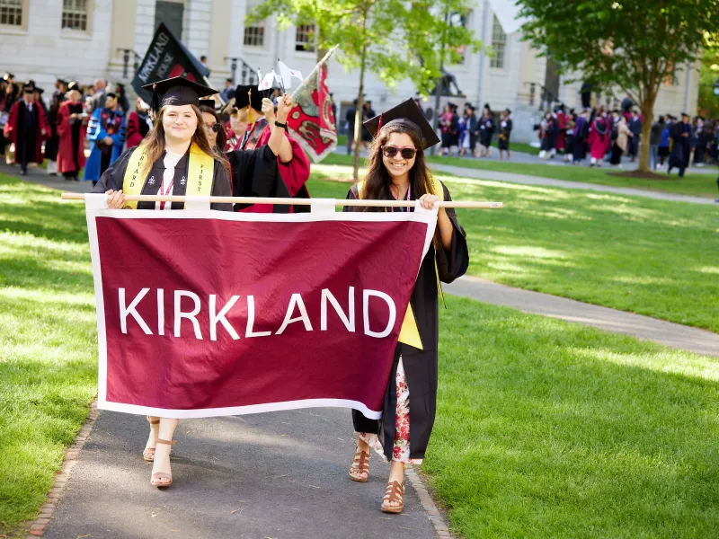 Hannah and a friend carry the Kirkland House banner at Commencement.