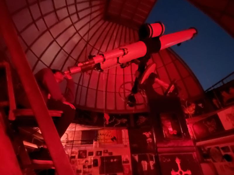 Rafid looking out through the Loomis-Michael student observatory telescope