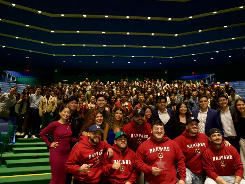 Grupo Frontera band members with the event's guests. People are smiling and happily posing for the picture.  