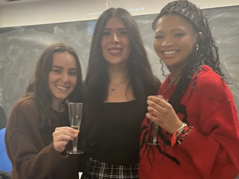 Three girls smiling for a picture. 