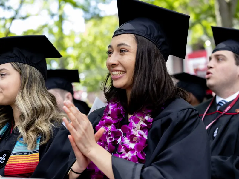 Student giving applause during commencement. 