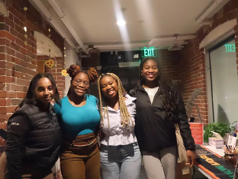 A picture of four black girls smiling and posing for a picture 