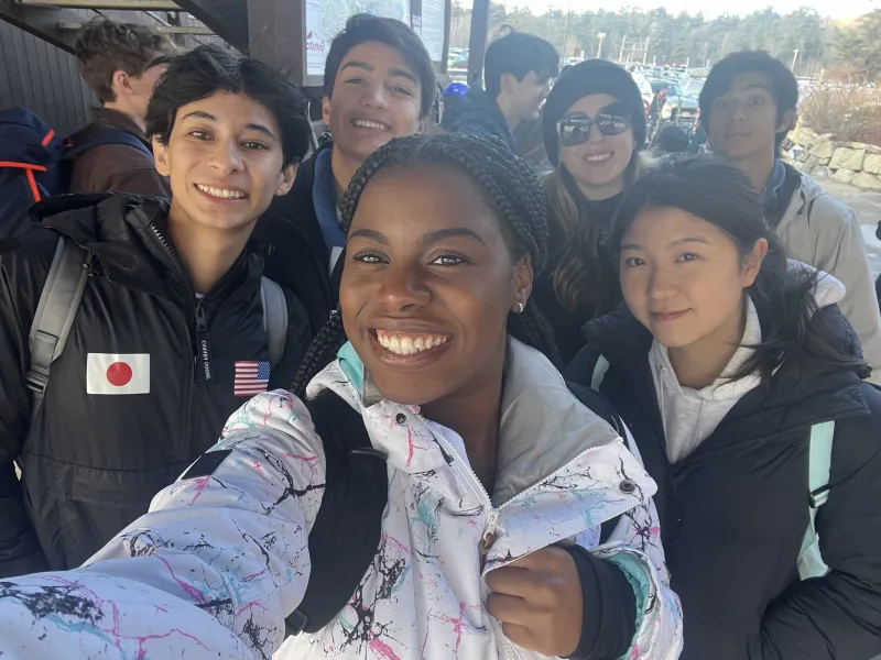 Group of students take a selfie in ski gear.