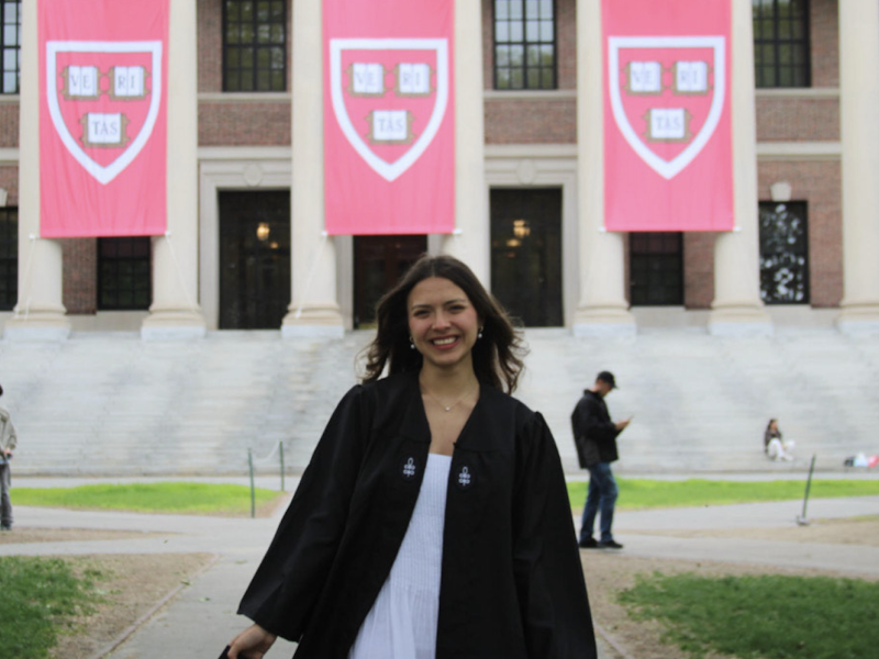 Ana posing in front of the Widener library in her graduation regalia. 