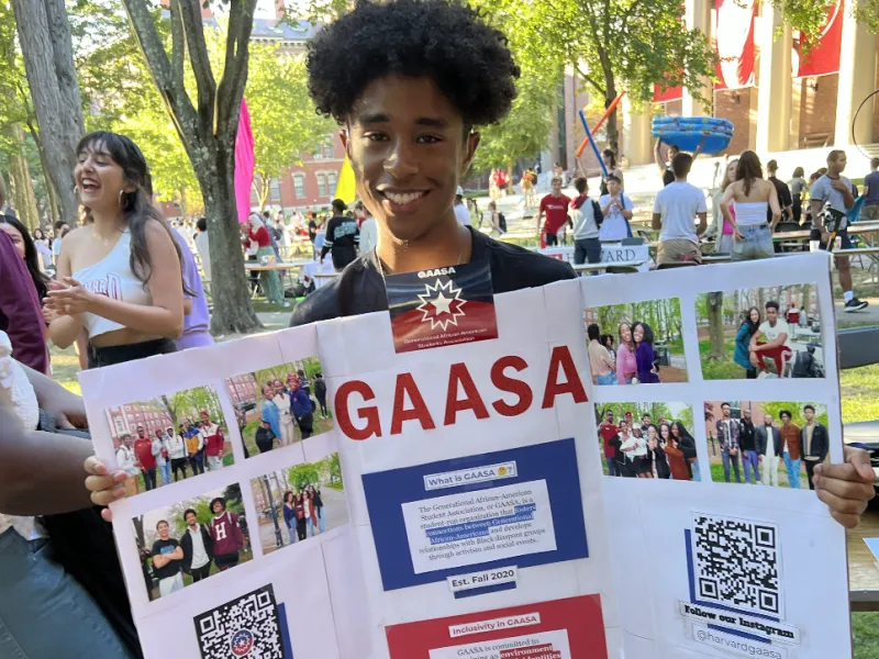 Ricardo holding up a poster board during the student activites fair