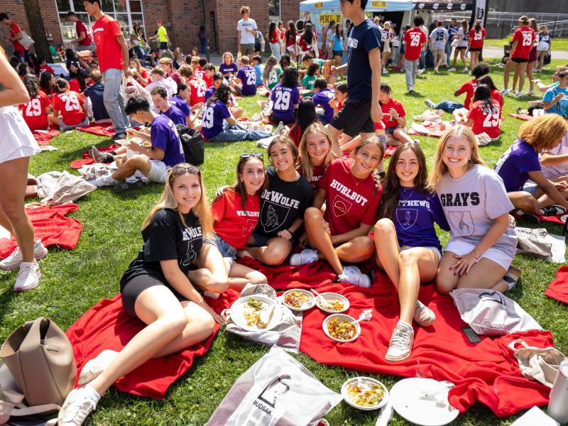 Class of 2029 students gather on a picnic blanket after Crimson Kickoff.