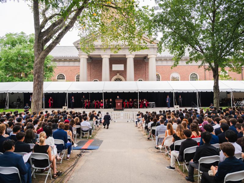 A wide shot of Convocation's stage and seating during the ceremony, located in front of Widener Library.
