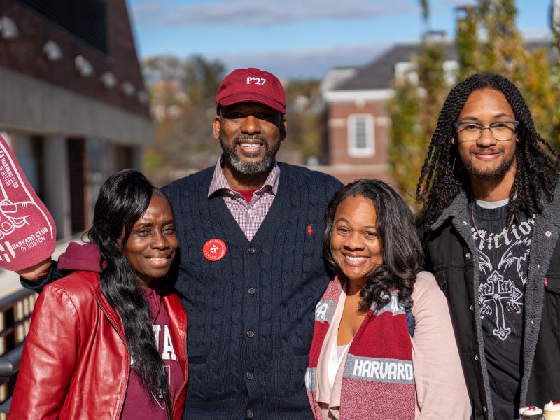 A family of four smiles together for a photo.