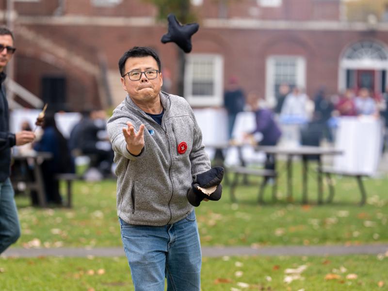 A man throws a bean bag during a game of cornhole.