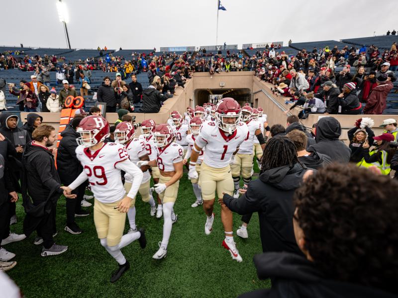 The Harvard football players running through the tunnel onto the field to start the game.