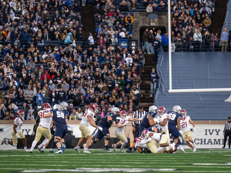 Harvard and Yale football players crashing into each other during the game.
