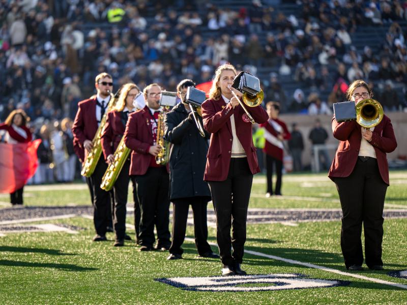 The Harvard band playing a song on the field during halftime.