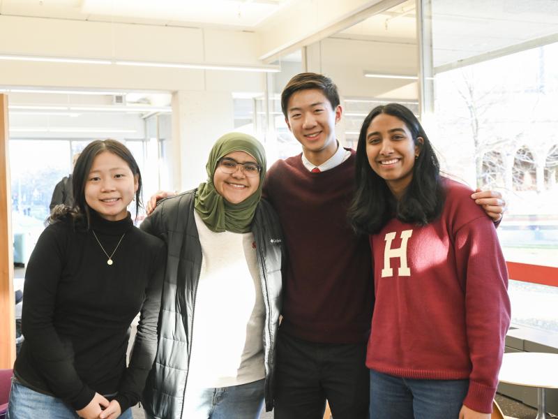 A group of four friends smile for a photo together after the ceremony.