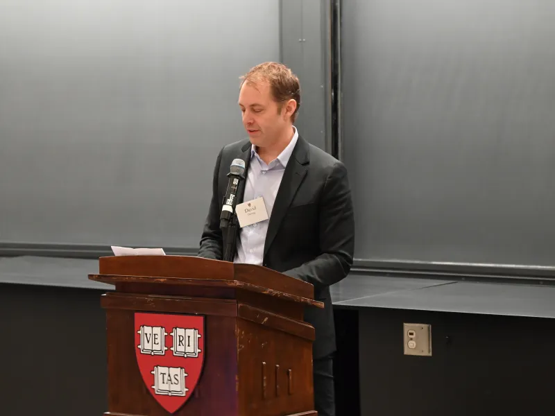 Danoff Dean of Harvard College David Deming delivering remarks at the podium.