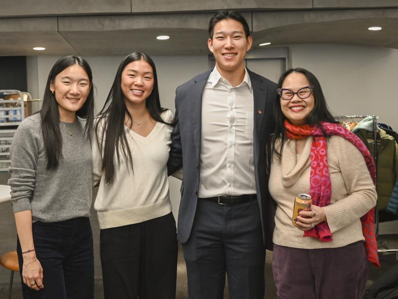 A group of four people smile together for a photo.