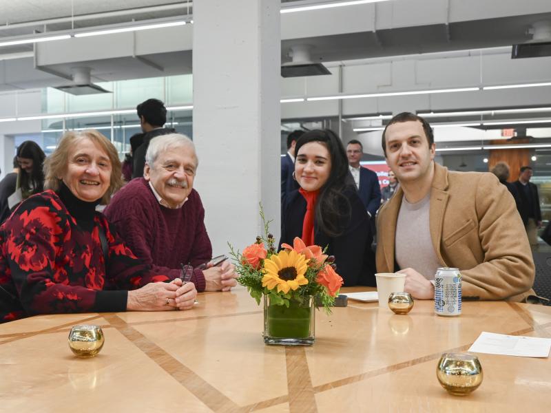A graduate smiles for a picture with their parents.