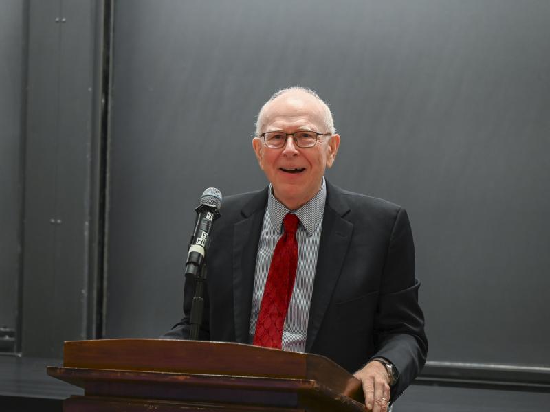 History professor Michael McCormick smiling at the podium during his remarks.