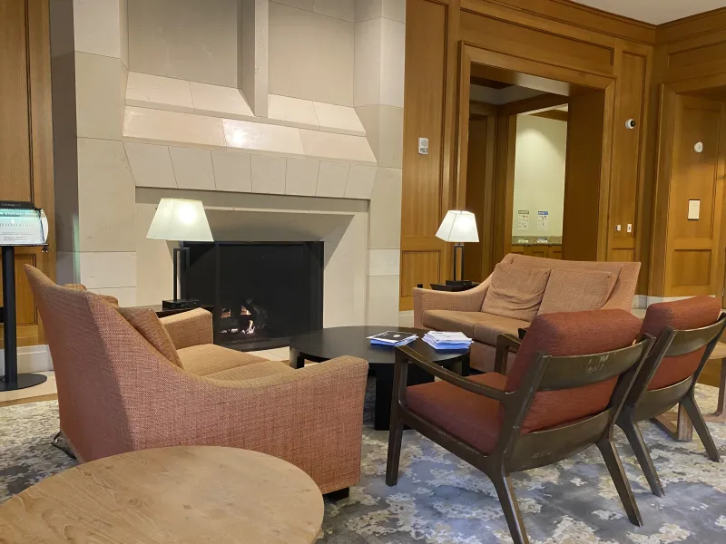 Four upholstered chairs positioned in a circle near a fireplace.