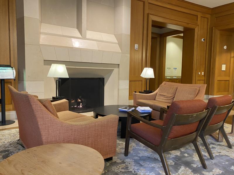 Four upholstered chairs positioned in a circle near a fireplace.