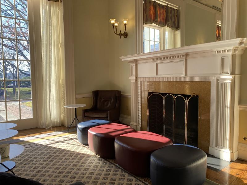 Two small red cushions sitting near a window with sunlight pouring in.