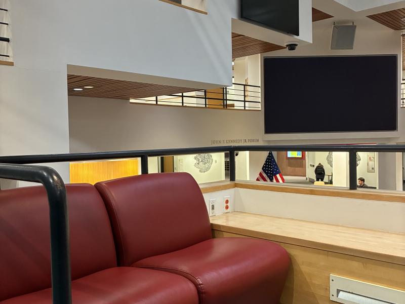 Two conjoined red ottomans inside the Institute of Politics Forum.