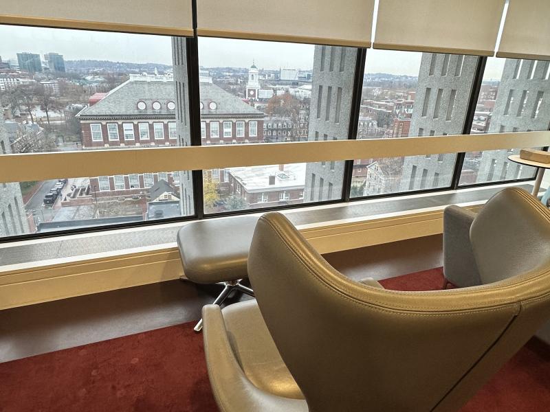 A lone chair overlooking an aerial view of campus out of the large window.